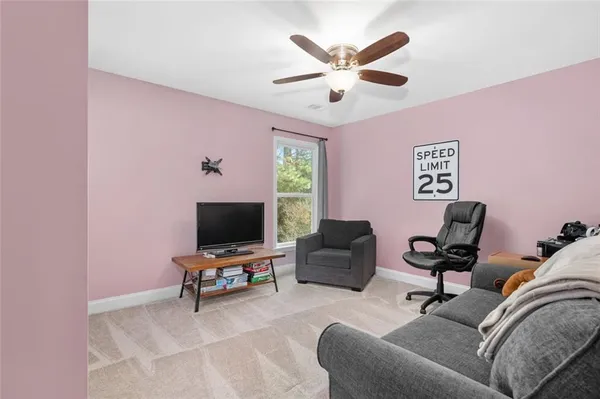 a living room with furniture and a ceiling fan
