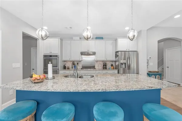 a kitchen with kitchen island granite countertop a table and chairs in it