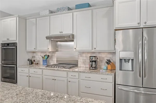 a kitchen with refrigerator and cabinets