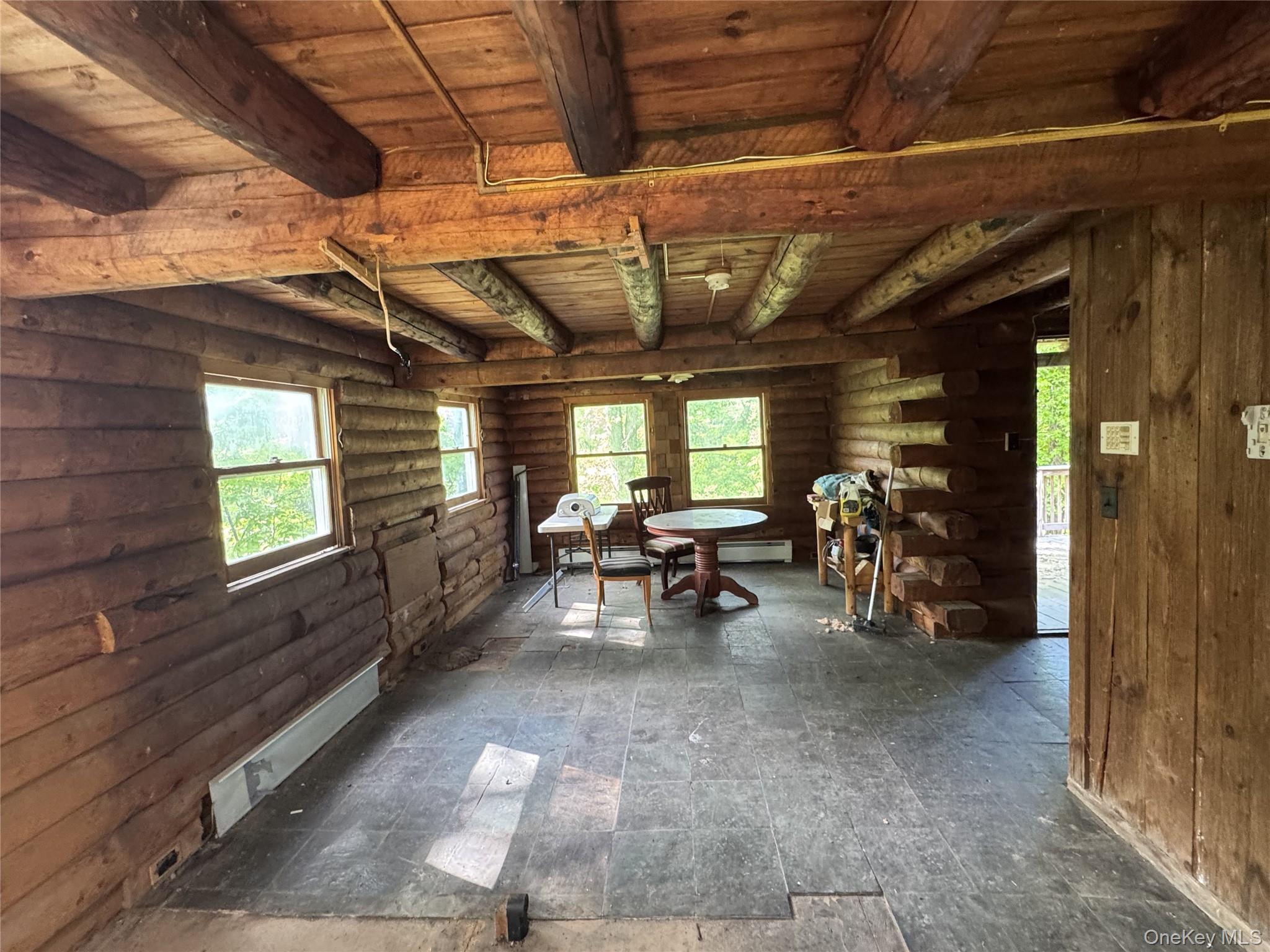 68 Union School Road Montgomery, NY 12549 - Photo 11 of 37 Dining space featuring wood ceiling with exposed beams, log walls, and baseboard heating