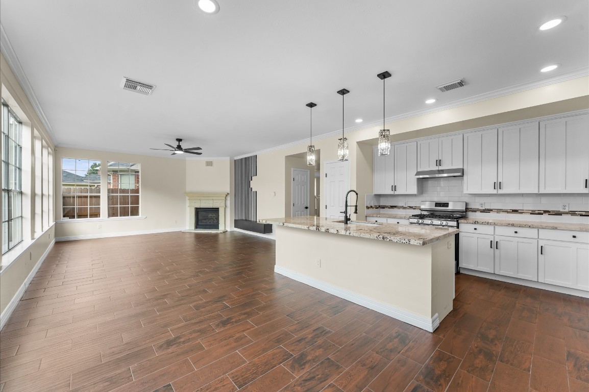 6330 Borg Breakpoint Drive Spring, TX 77379 - Photo 14 of 49 a large kitchen with granite countertop a stove top oven a sink a counter space and wooden floor