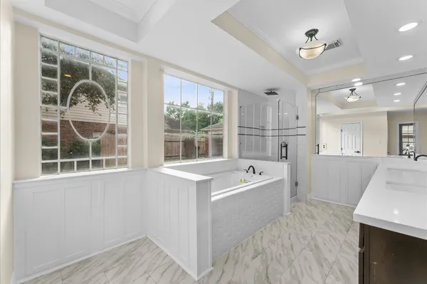 a bathroom with a tub a sink and a large window