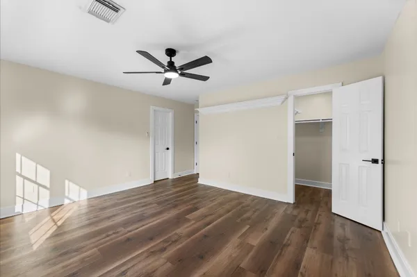a view of empty room with wooden floor