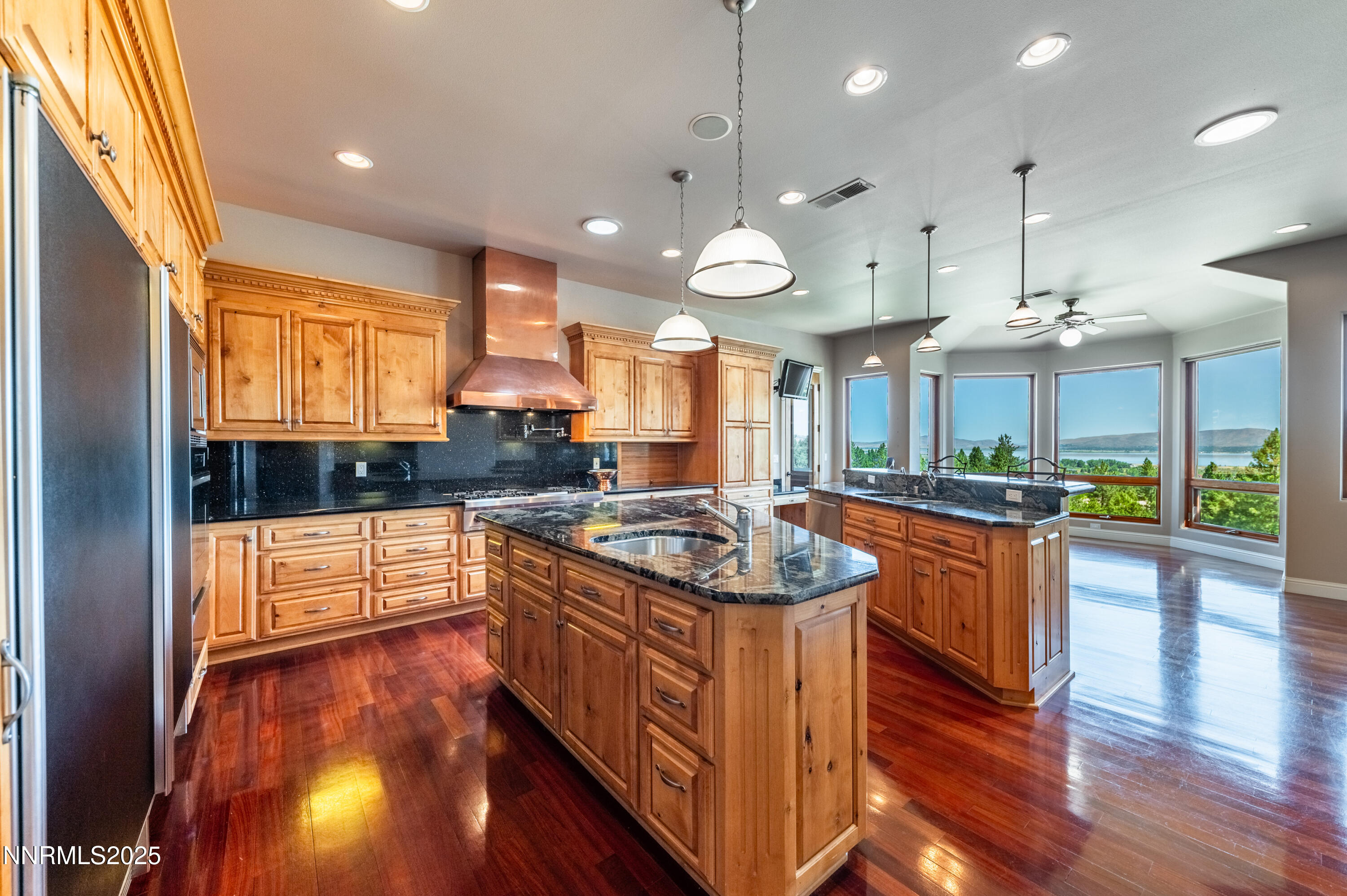 7450 Bryan Canyon Road Washoe Valley, NV 89704 - Photo 9 of 34 a kitchen with stainless steel appliances granite countertop sink stove and wooden floor