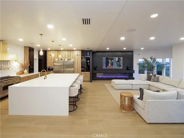 a large living room with stainless steel appliances kitchen island a table and a couch