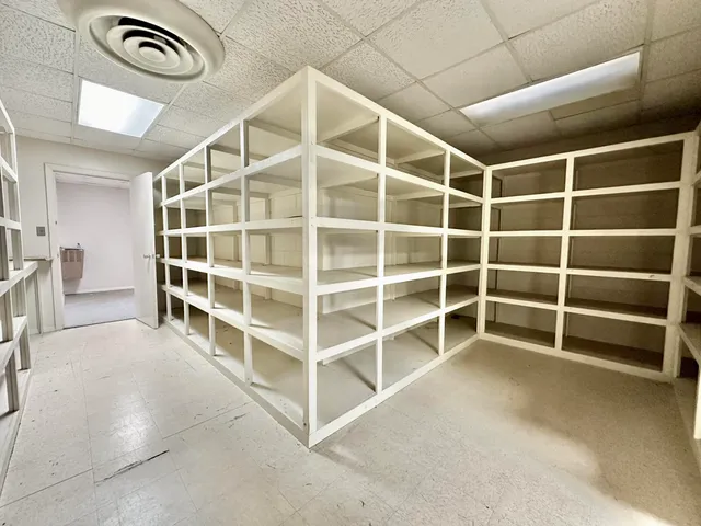 an empty room with a ceiling fan and window