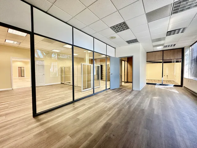 a view of an empty room window and wooden floor