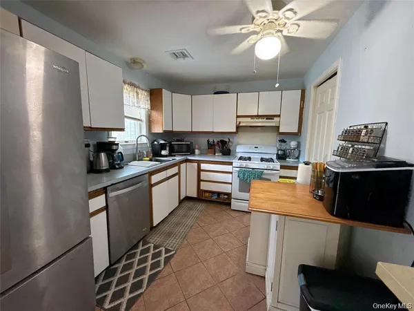 a kitchen with stainless steel appliances granite countertop a sink counter space cabinets and a refrigerator