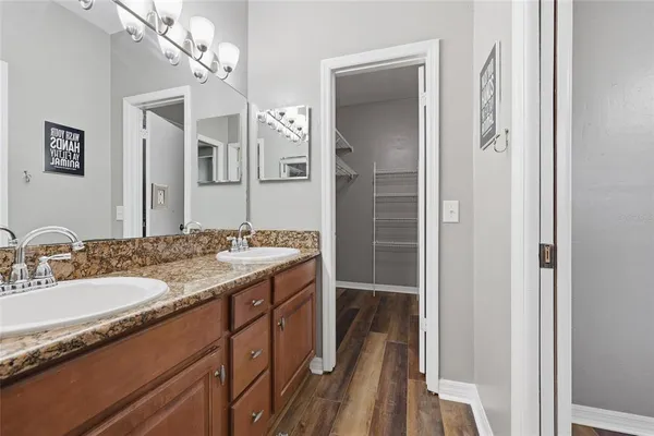 a bathroom with a granite countertop sink a mirror and a shower