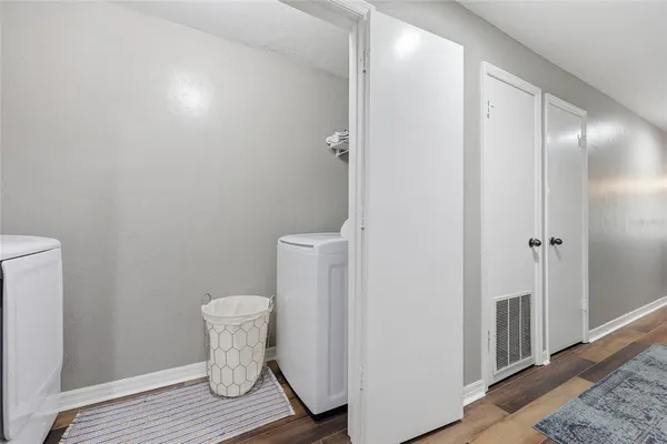 a bathroom with a toilet and a wooden floor