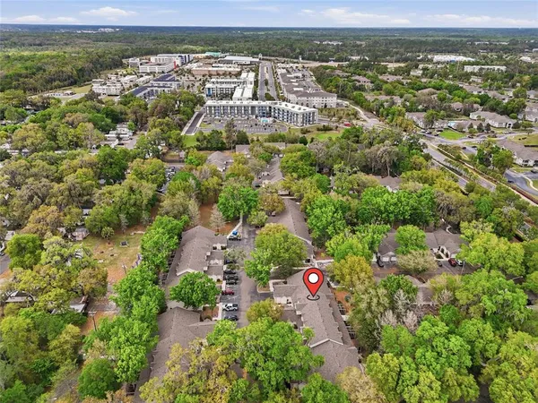 an aerial view of residential building with parking and yard