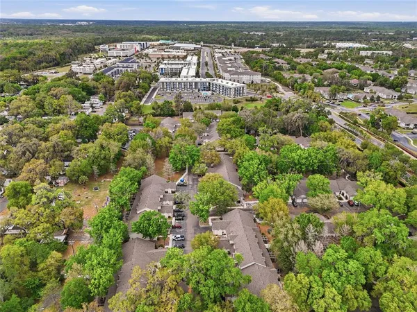 an aerial view of residential building with parking and yard