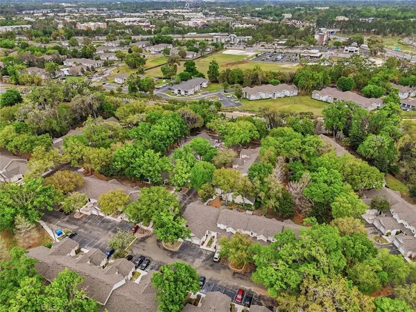 an aerial view of residential houses with outdoor space and trees