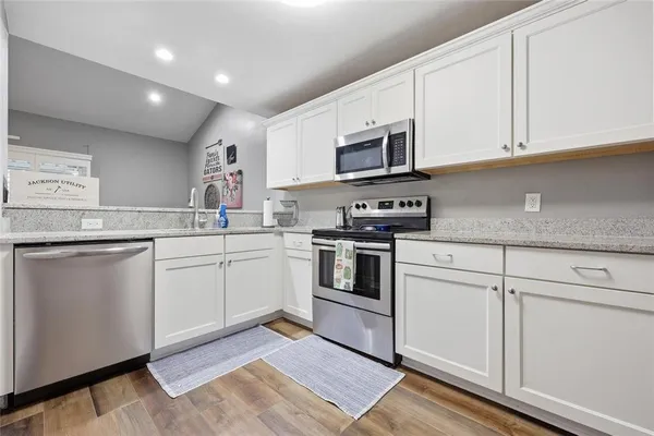 a kitchen with white cabinets stainless steel appliances and sink