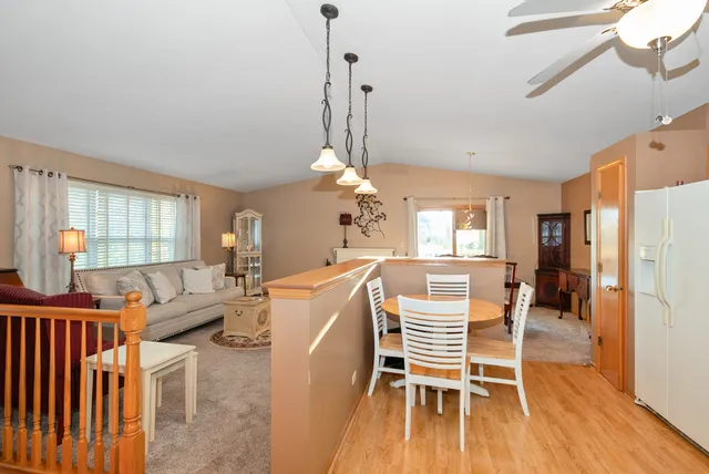 a dining room with wooden floor a chandelier a wooden table and chairs