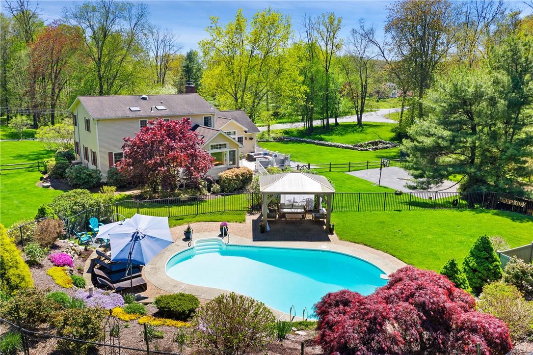 a view of a swimming pool with lawn chairs and plants