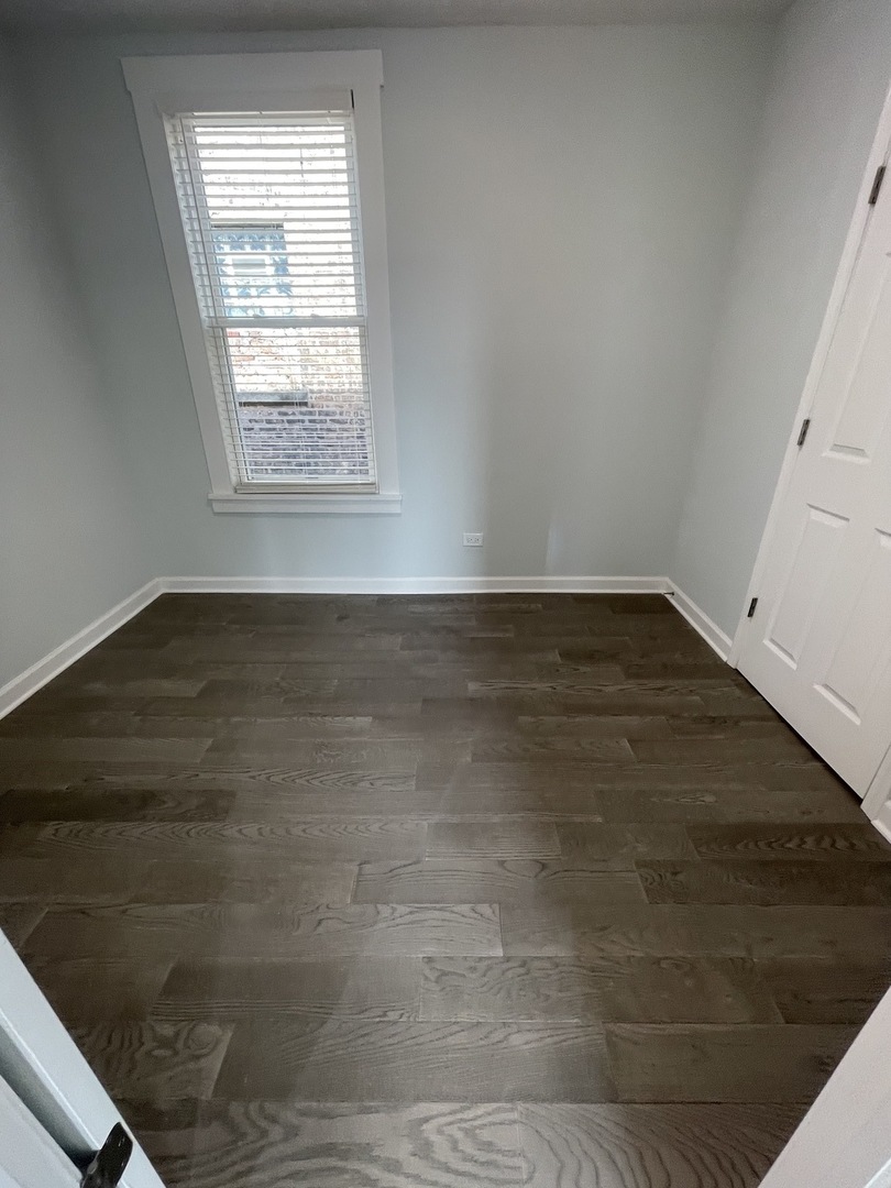 2416 North Springfield Avenue, Unit 2 Chicago, IL 60647 - Photo 6 of 9 an empty room with wooden floor and windows