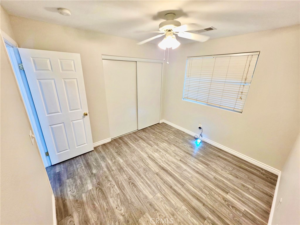 15354 Kiamichi Road Apple Valley, CA 92307 - Photo 12 of 22 a view of empty room with wooden floor and fan