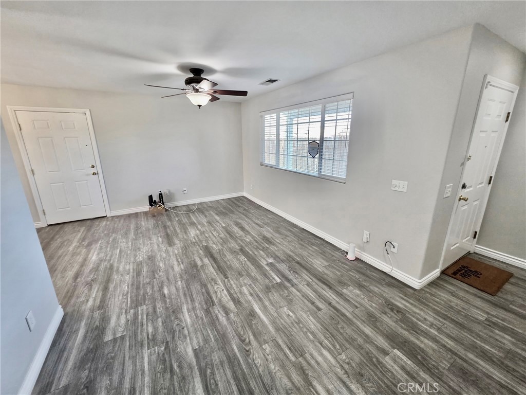 15354 Kiamichi Road Apple Valley, CA 92307 - Photo 5 of 22 wooden floor in an empty room with a window