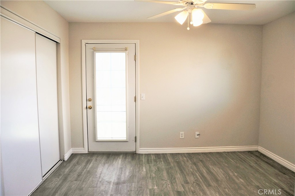 15354 Kiamichi Road Apple Valley, CA 92307 - Photo 8 of 22 an empty room with wooden floor and windows