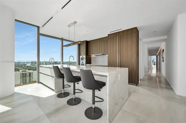 a kitchen with stainless steel appliances kitchen island granite countertop a table chairs in it and a window