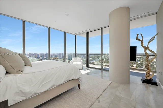 a spacious bedroom with a bed window and lamp