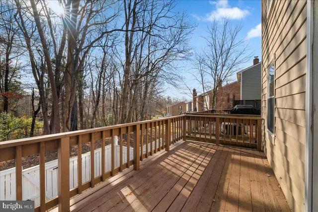 a view of a balcony with wooden floor and fence