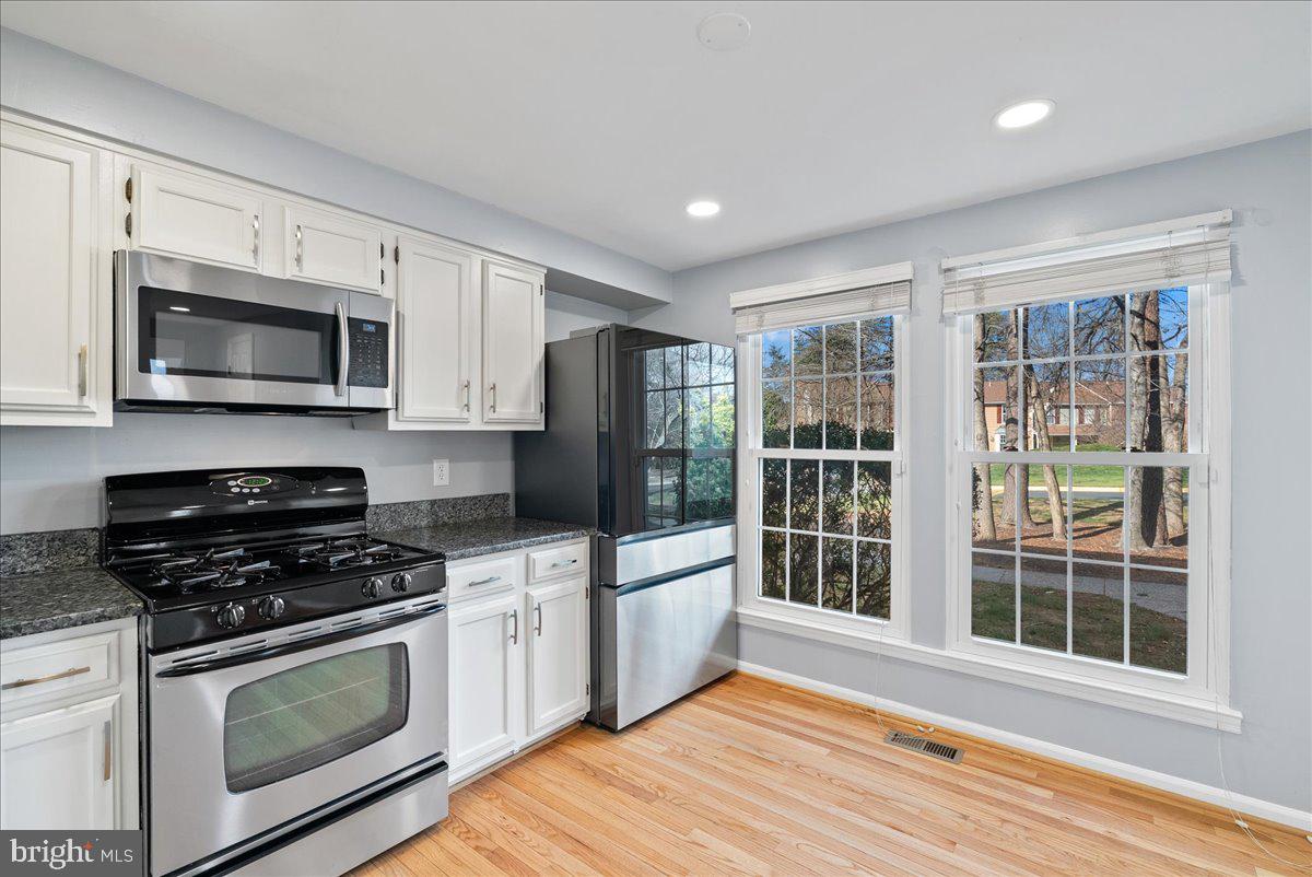 1481 Autumn Ridge Circle Reston, VA 20194 - Photo 6 of 26 a kitchen with granite countertop a stove and a microwave
