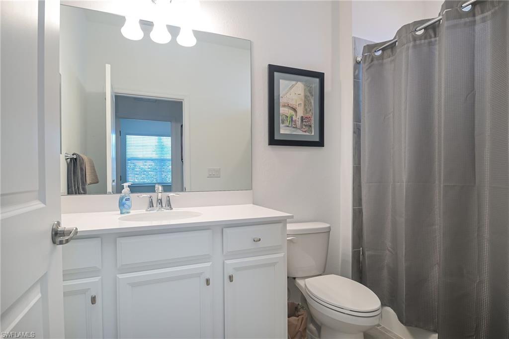 2532 Kona Way Naples, FL 34120 - Photo 15 of 30 a bathroom with a toilet a sink a vanity and mirror
