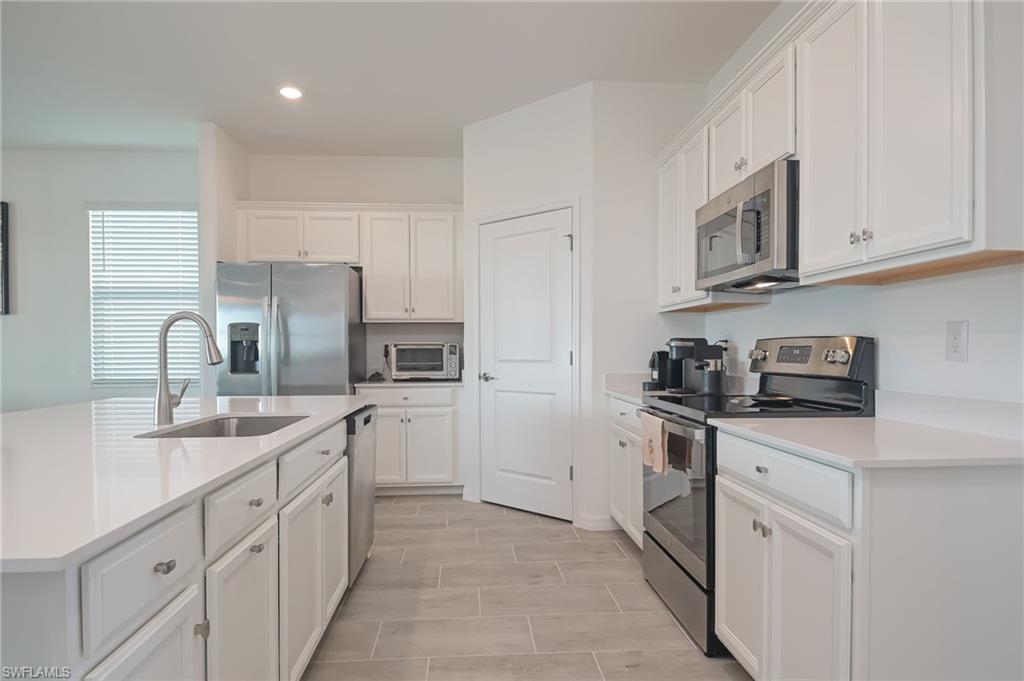 2532 Kona Way Naples, FL 34120 - Photo 8 of 30 a kitchen with stainless steel appliances granite countertop a sink stove refrigerator and cabinets