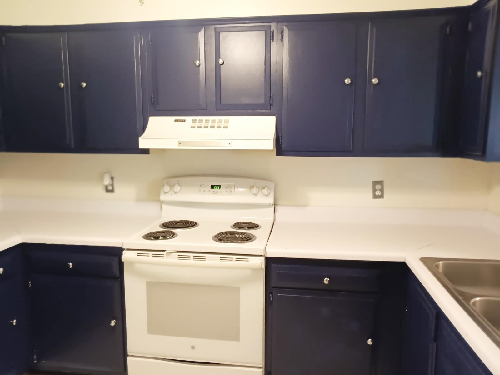 1770 Crompton 6th Square, Unit 29 Memphis, TN 38134 - Photo 8 of 21 Kitchen with white electric range, blue cabinetry, and light countertops