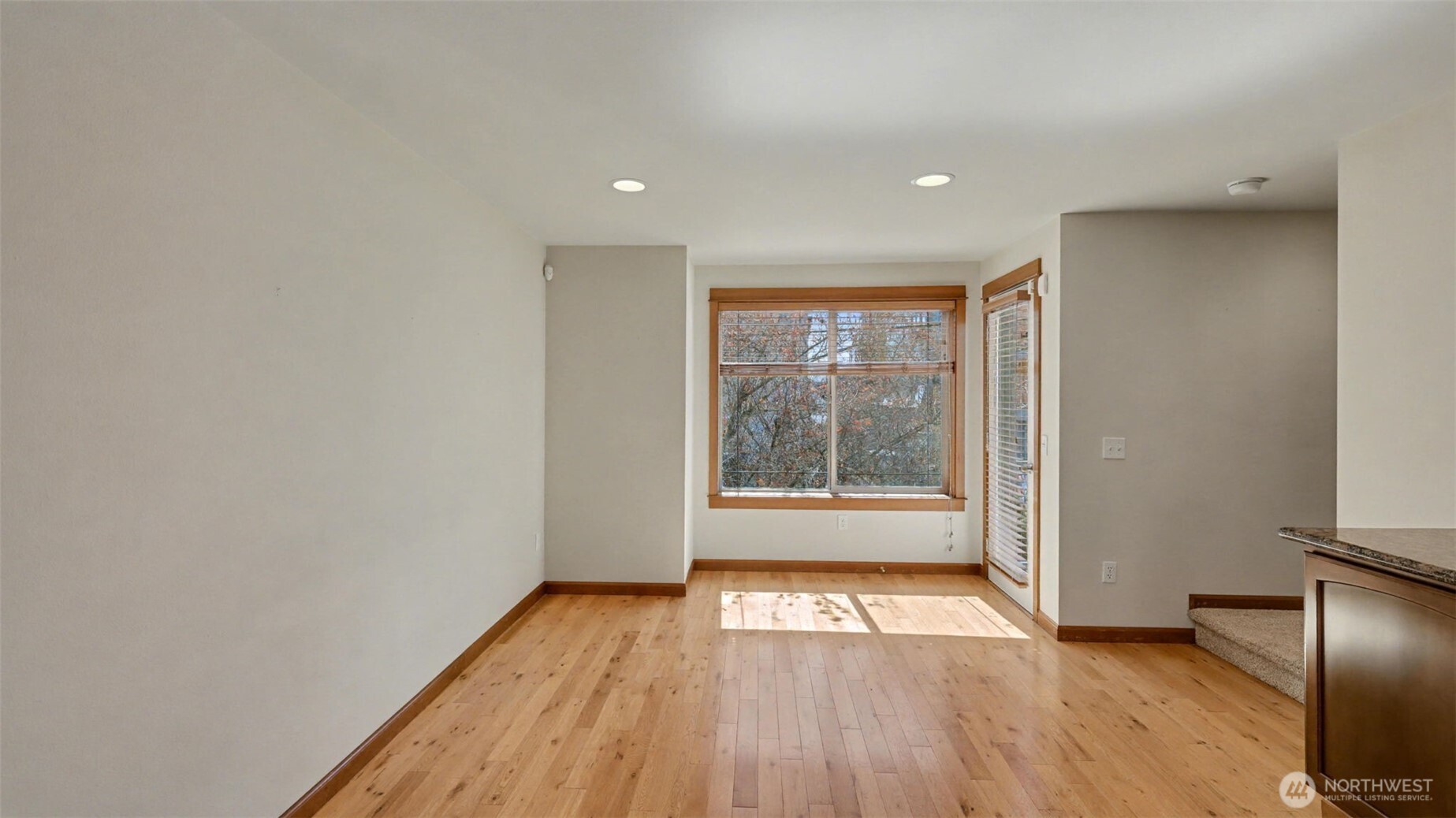 1120 North 92nd Street, Unit A Seattle, WA 98103 - Photo 11 of 22 a view of an empty room with wooden floor and a window