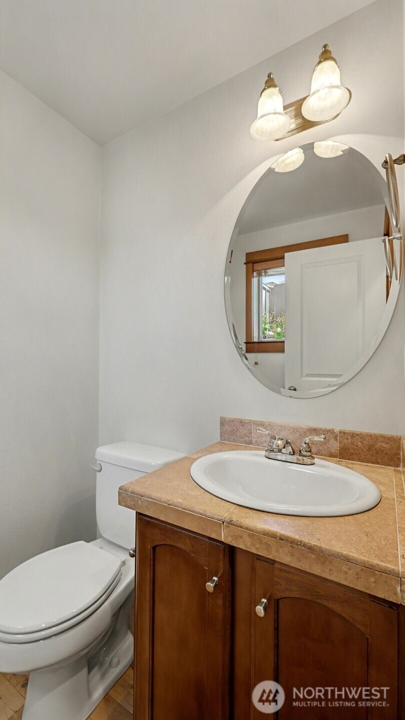 1120 North 92nd Street, Unit A Seattle, WA 98103 - Photo 13 of 22 a bathroom with a toilet sink and mirror