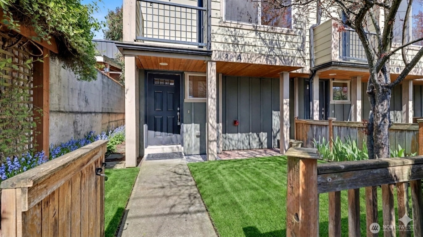 1120 North 92nd Street, Unit A Seattle, WA 98103 - Photo 3 of 22 a front view of a house with a yard table and chairs