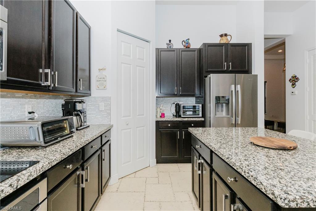 5169 Roma Street South Ave Maria, FL 34142 - Photo 18 of 49 a kitchen with granite countertop counter top space cabinets and stainless steel appliances
