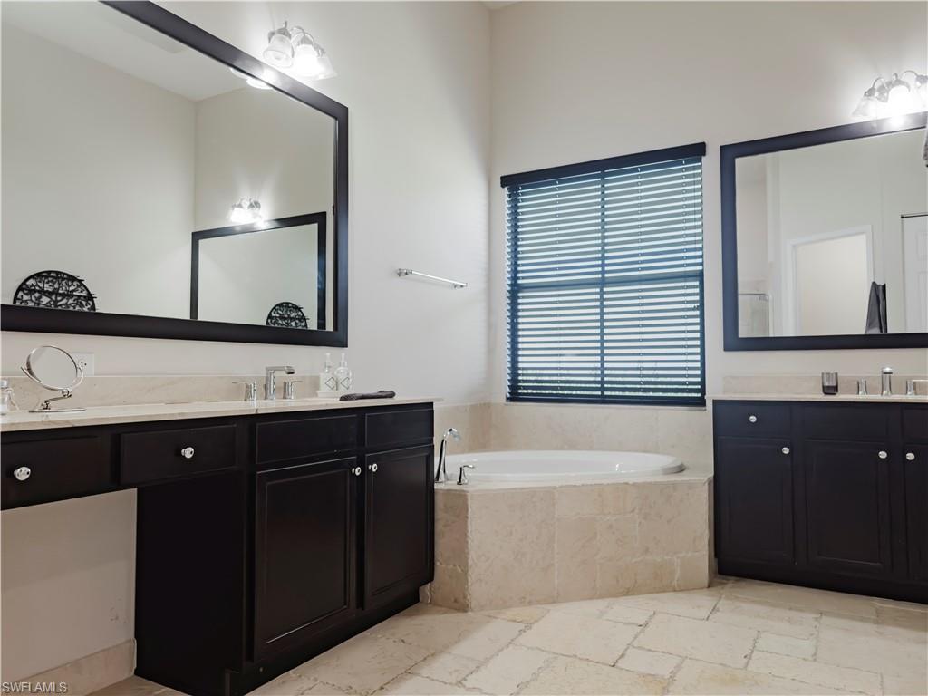 5169 Roma Street South Ave Maria, FL 34142 - Photo 27 of 49 a bathroom with a bathtub sink and mirror