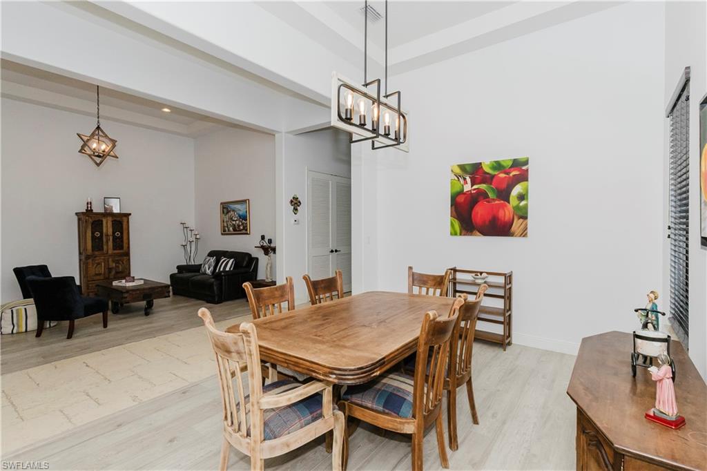 5169 Roma Street South Ave Maria, FL 34142 - Photo 10 of 49 a view of a dining room with furniture a chandelier and wooden floor