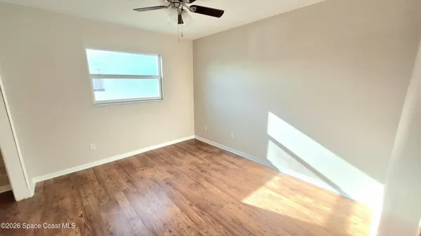 a view of a big room with wooden floor and windows