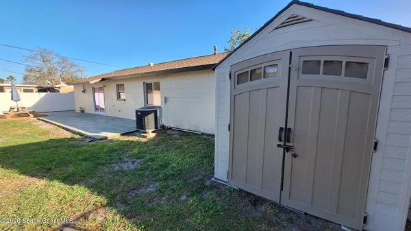 a view of backyard of house and wooden deck