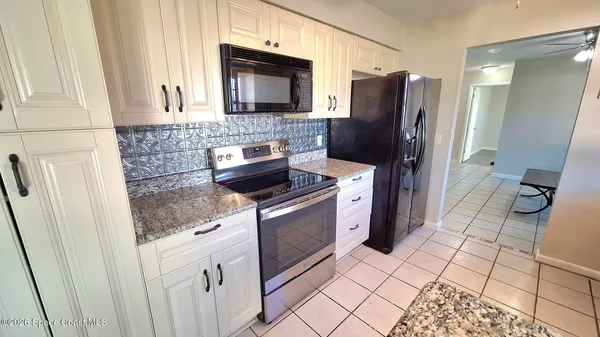 a kitchen with stainless steel appliances granite countertop a refrigerator stove and sink