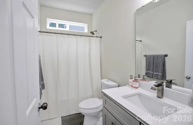 a bathroom with a granite countertop sink toilet and a mirror