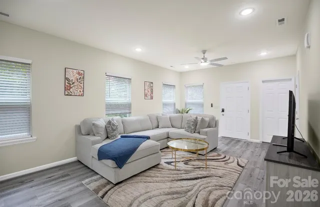 a living room with furniture a window and a flat screen tv