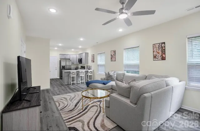 a living room with furniture a flat screen tv and a window