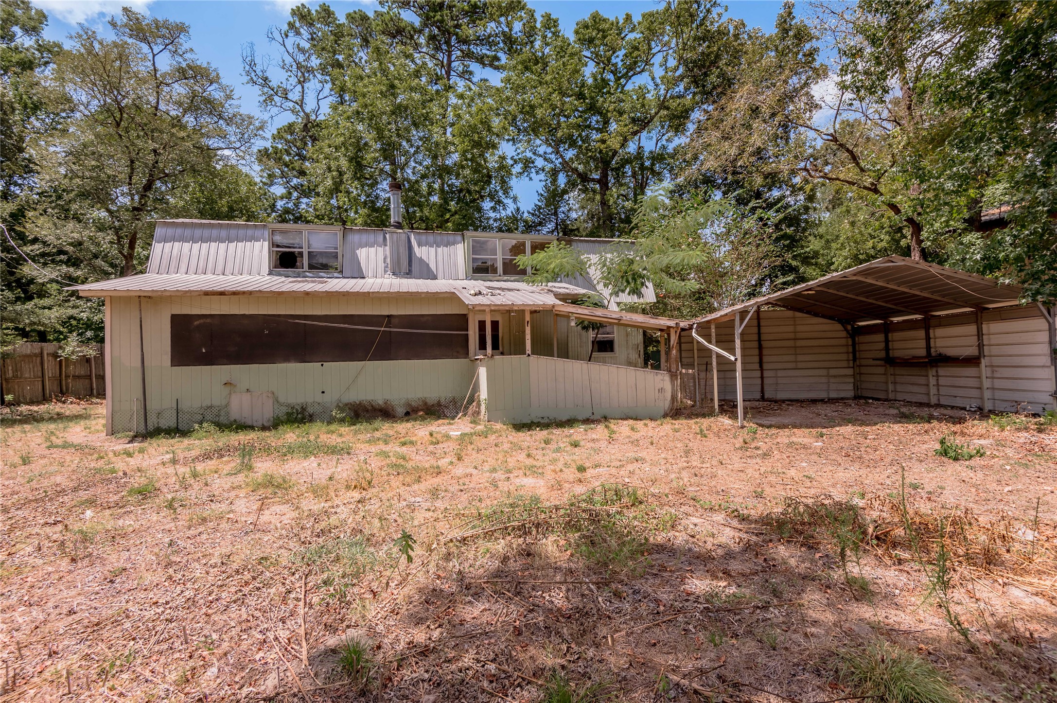 8 Creek Road Huntsville, TX 77320 - Photo 35 of 50 Charming fixer-upper with great potential, featuring a spacious yard and a convenient carport. Surrounded by mature trees, this property offers a serene setting perfect for customization.
