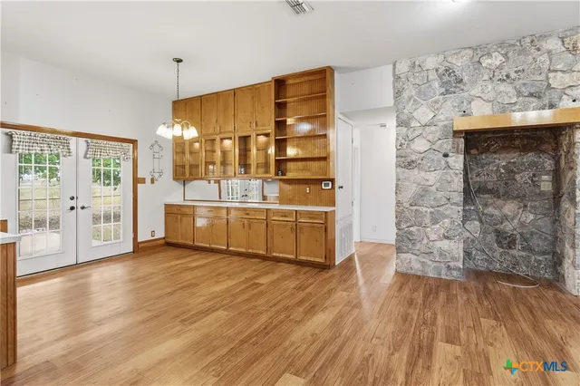 a large kitchen with stainless steel appliances a large counter top a stove a sink and a refrigerator