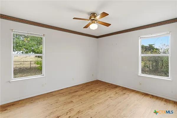 a view of a big room with wooden floor and a window