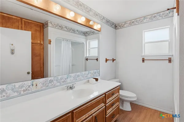 a bathroom with a sink a toilet and shower