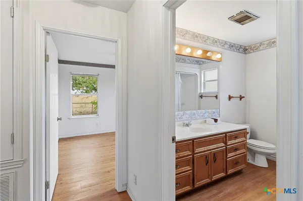 a spacious bathroom with a sink a toilet and a mirror