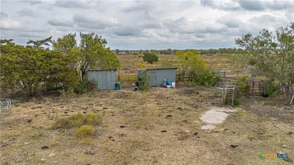 a view of a dry yard with wooden fence