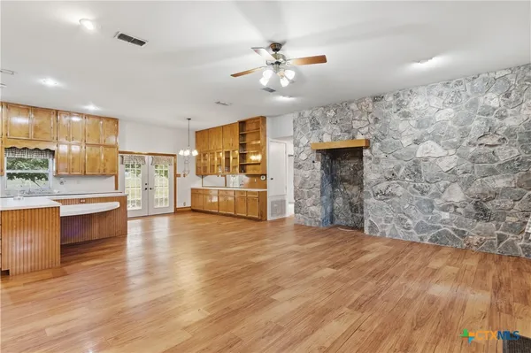 a view of a livingroom with furniture a fireplace wooden floor and chandelier